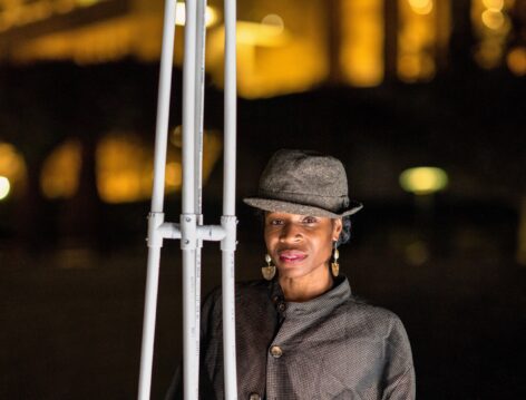Marjani standing next to frame of Memoirs of a Unicorn (horn), re-visioned with PVC Pipe for Garden of Unicorns installedat the Getty Museum. Photo by Cassia Davis. © J Paul Getty Trust 2022.
