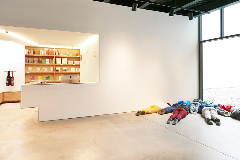 A wide space, with dancers tucked into the corner, laying face down. Kim Brandt, The Volume, 2017. In Practice: Material Deviance, SculptureCenter, New York. Photo by Kyle Knodell