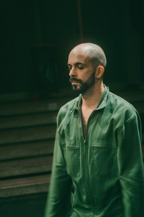 Csaba Molnár stands with his eyes closed. He has a short beard and a shaved head. he wears a green long sleeve collared top. Photo by Ofner Gergely.