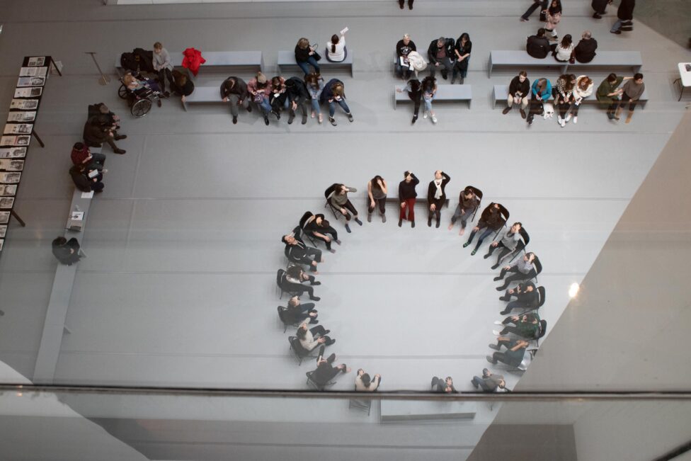 2019, an aerial shot of a group of dancers in sitting a circle for a workshop with Jimena Paz for Movement Research at MoMa. Photo by Andrew Kim