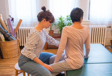 Anat monitors a client while they sit in and move their torso in a spiral position. Photo courtesy of the artist.