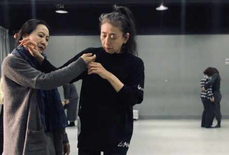 Eiko assists another in a class setting. Photo by Qian Min.