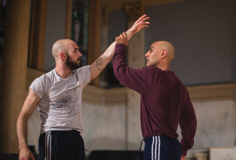 Paul, on the right in the burgundy shirt, holds the arm of Jack Blackmon, on the left, while they look directly at each other. Photo by David Gonsier.