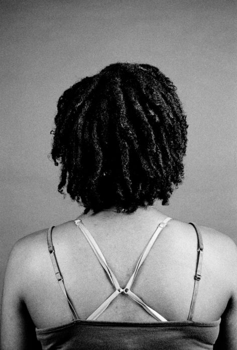 black and white portrait of Marie facing away from the camera with a dark background