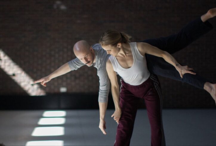 Bradley Teal Ellis balances his body on Shura Baryshnikov's lower back as she stands in a shallow squat with her chest pitched forward. Photo by Anna Maynard