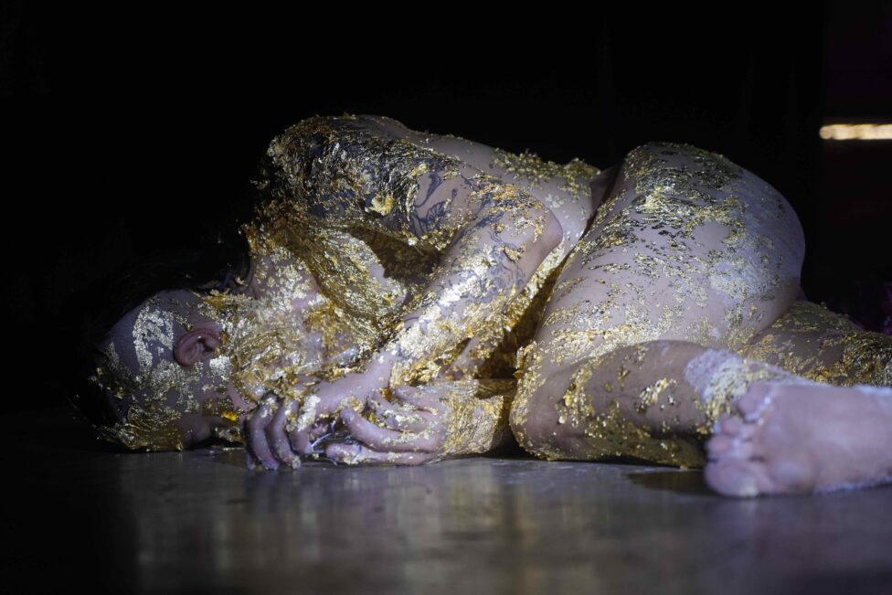 ID: Riven lies collapsed on the ground in a fetal position, covered in gold, some parts peeled off like a second skin.
Photo credit: Puttisin Choojesroom